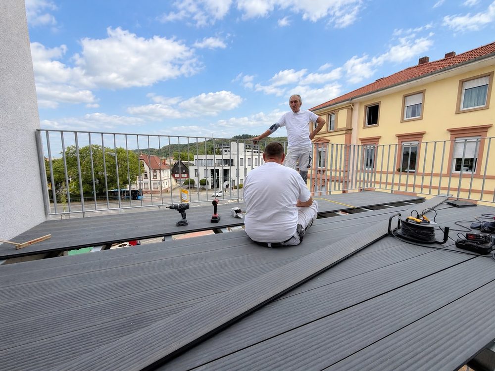 Handwerker verlegen den Belag einer Dachterrasse